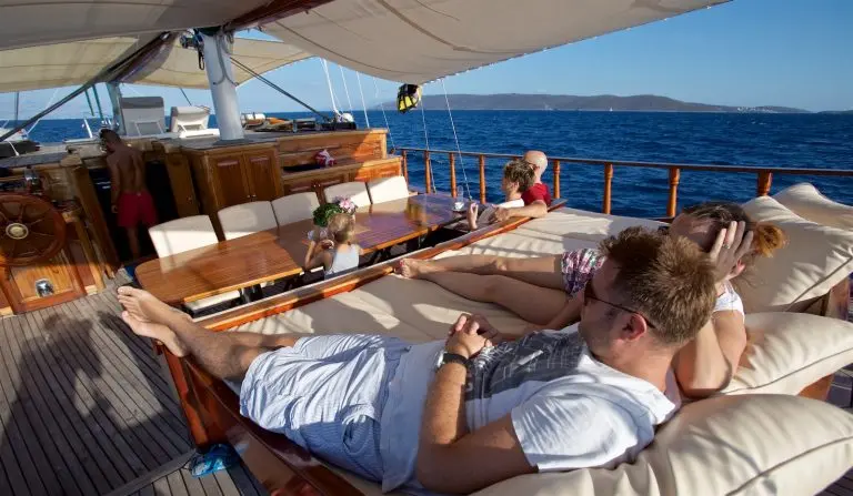 Parents resting on a mattress on the deck of the gulet